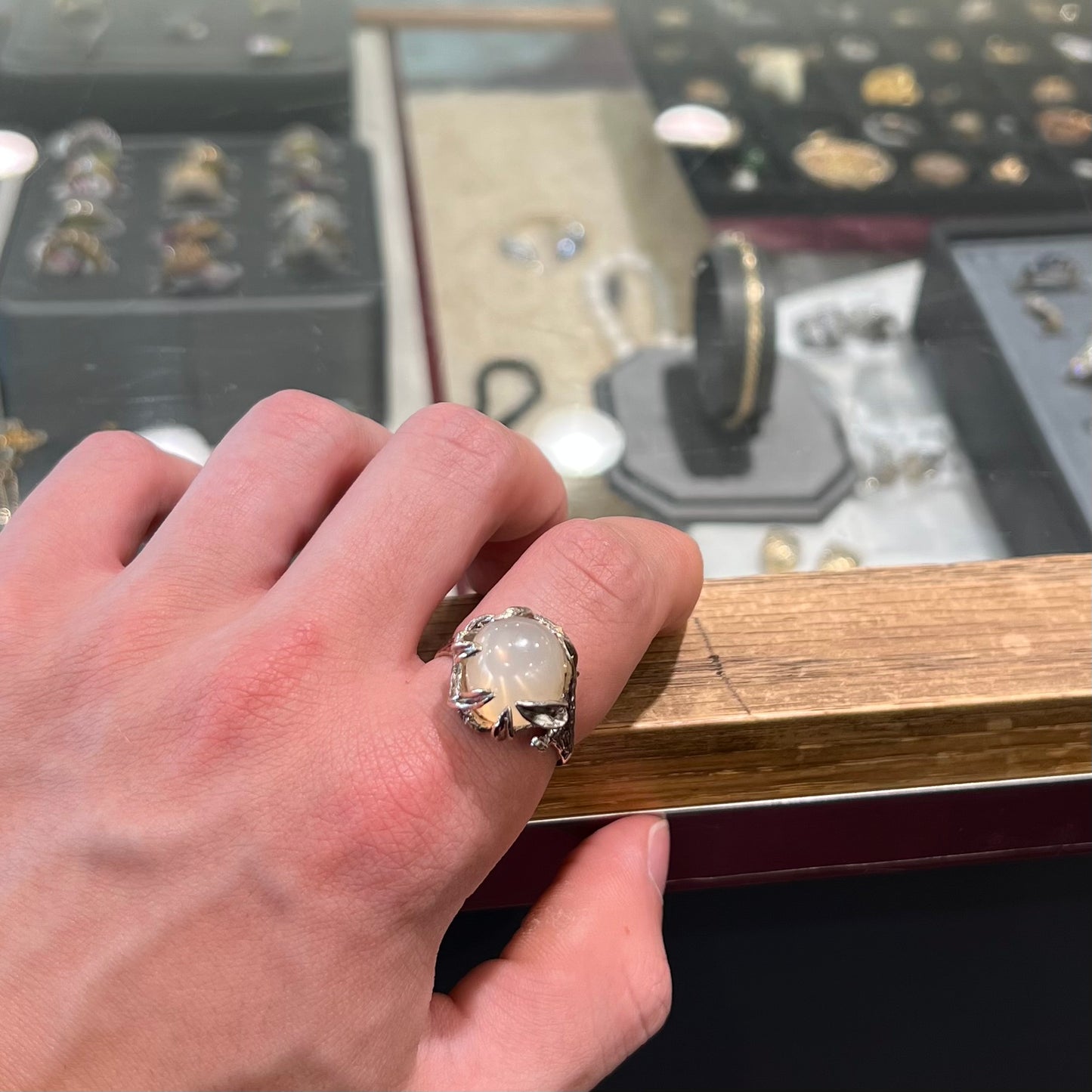 A ladies' organic style white gold moonstone ring. The moonstone shows white adularescence on a creamy white body color. Prongs resemble leaves holding the stone.