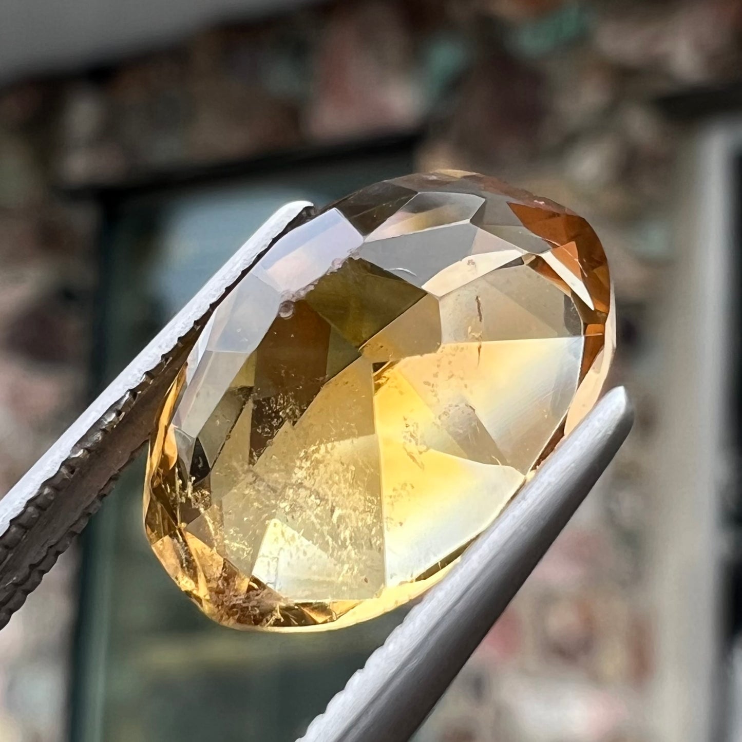 A loose, oval cut citrine gemstone. The stone is heavily included and roughly cut.