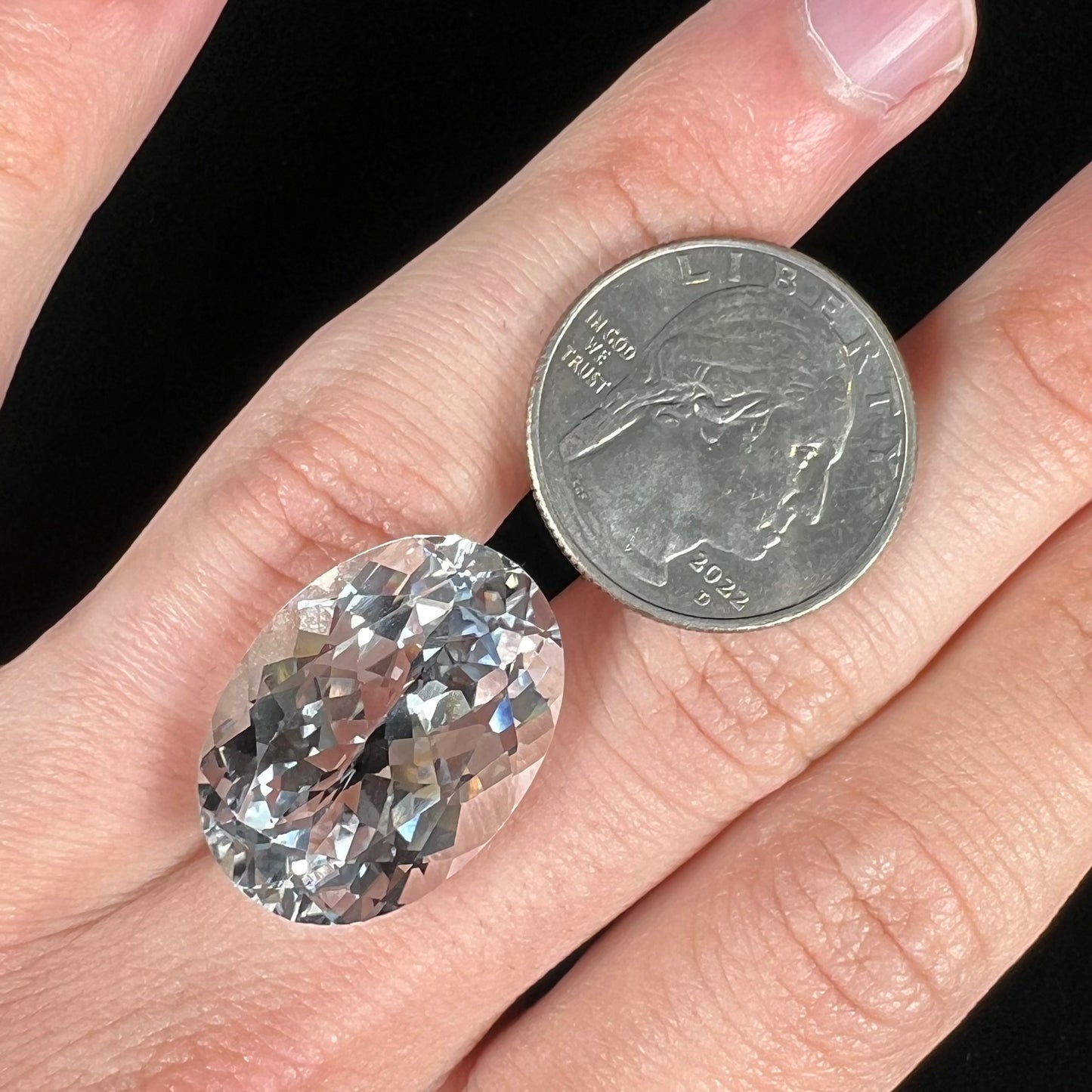 A loose, faceted oval cut white topaz gemstone. The stone is large in size.