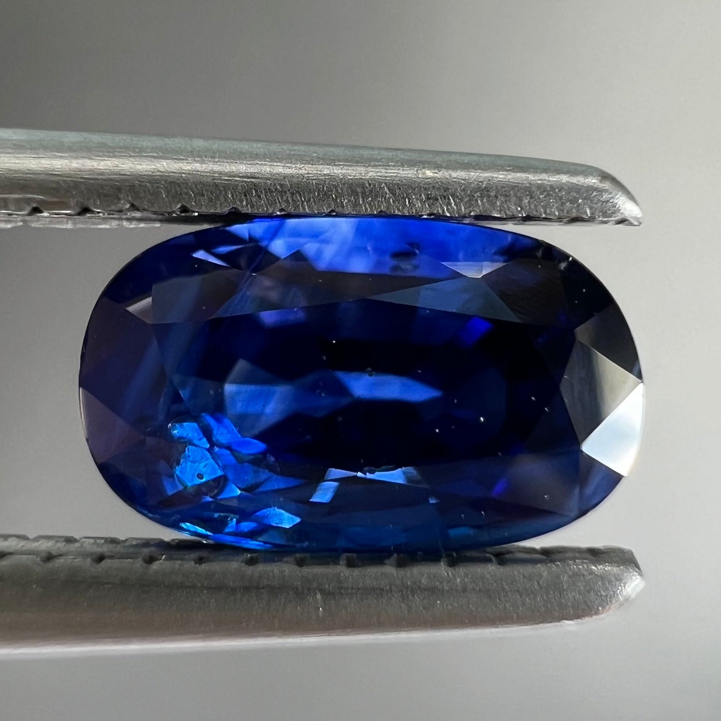 A loose, elongated oval cut blue sapphire gemstone.