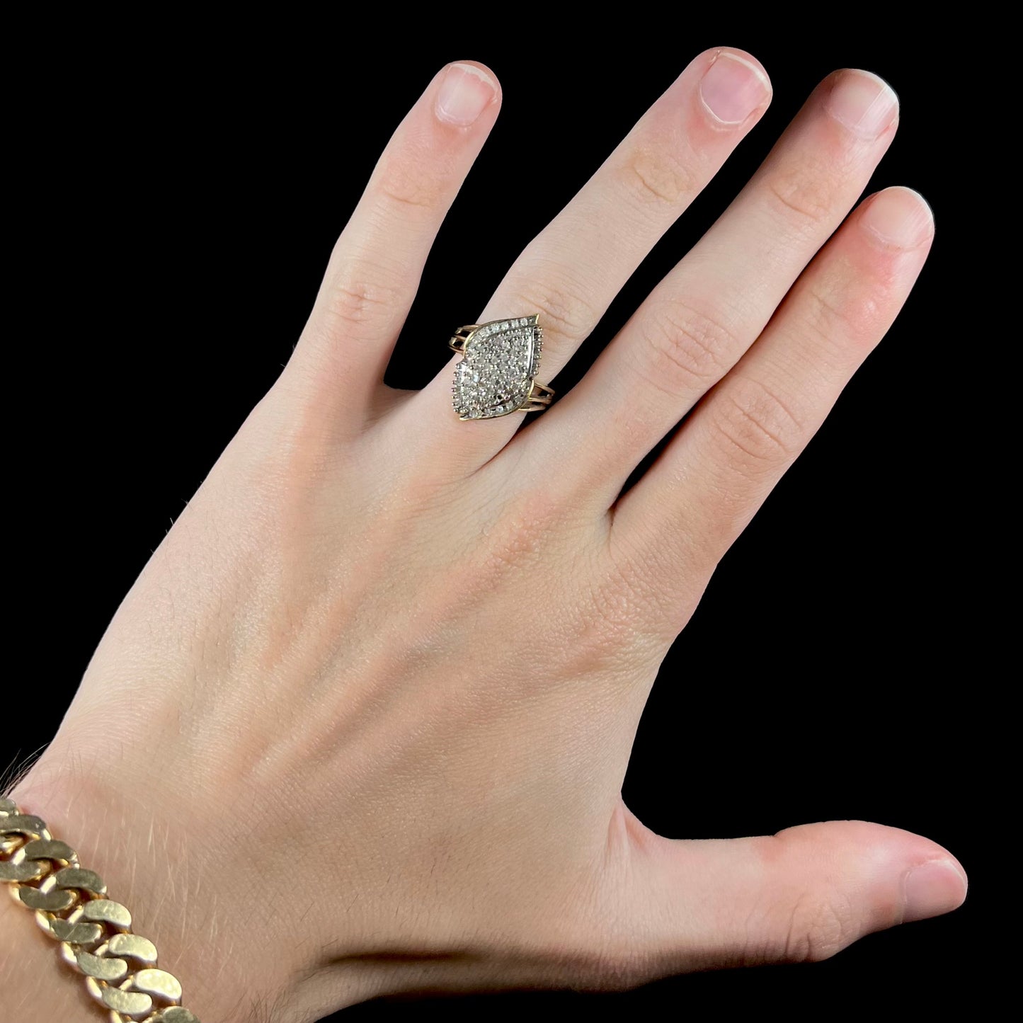 A ladies' yellow gold and diamond cluster ring. The diamonds are round and baguette shaped, and the ring is navette shaped.
