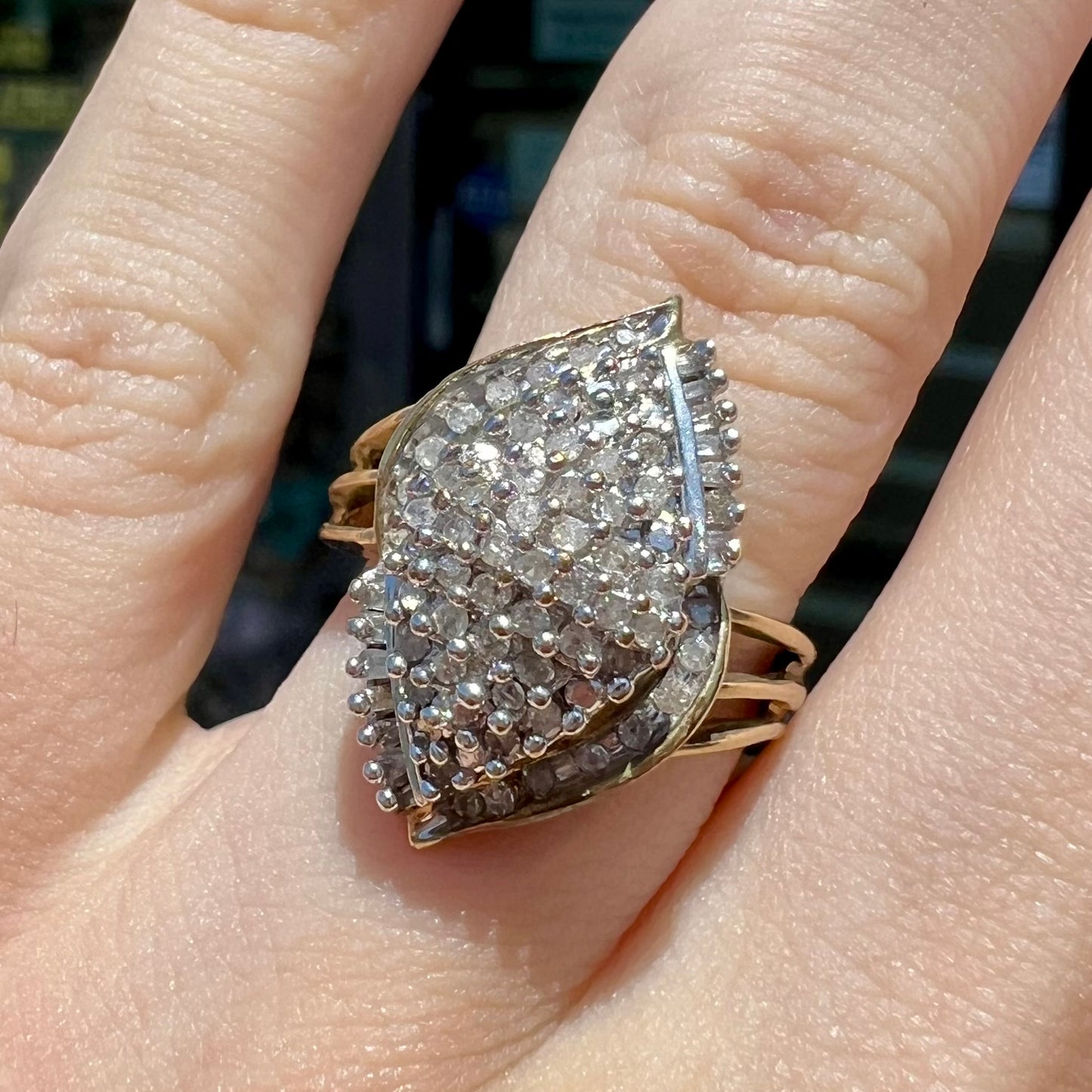 A ladies' yellow gold and diamond cluster ring. The diamonds are round and baguette shaped, and the ring is navette shaped.