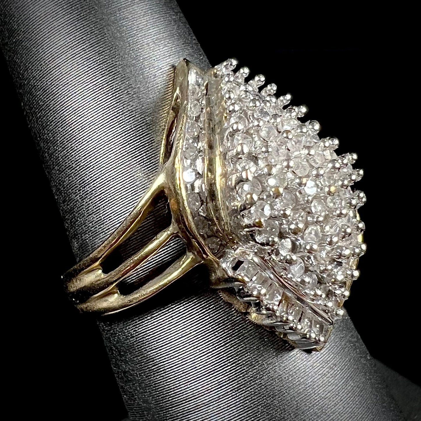 A ladies' yellow gold and diamond cluster ring. The diamonds are round and baguette shaped, and the ring is navette shaped.