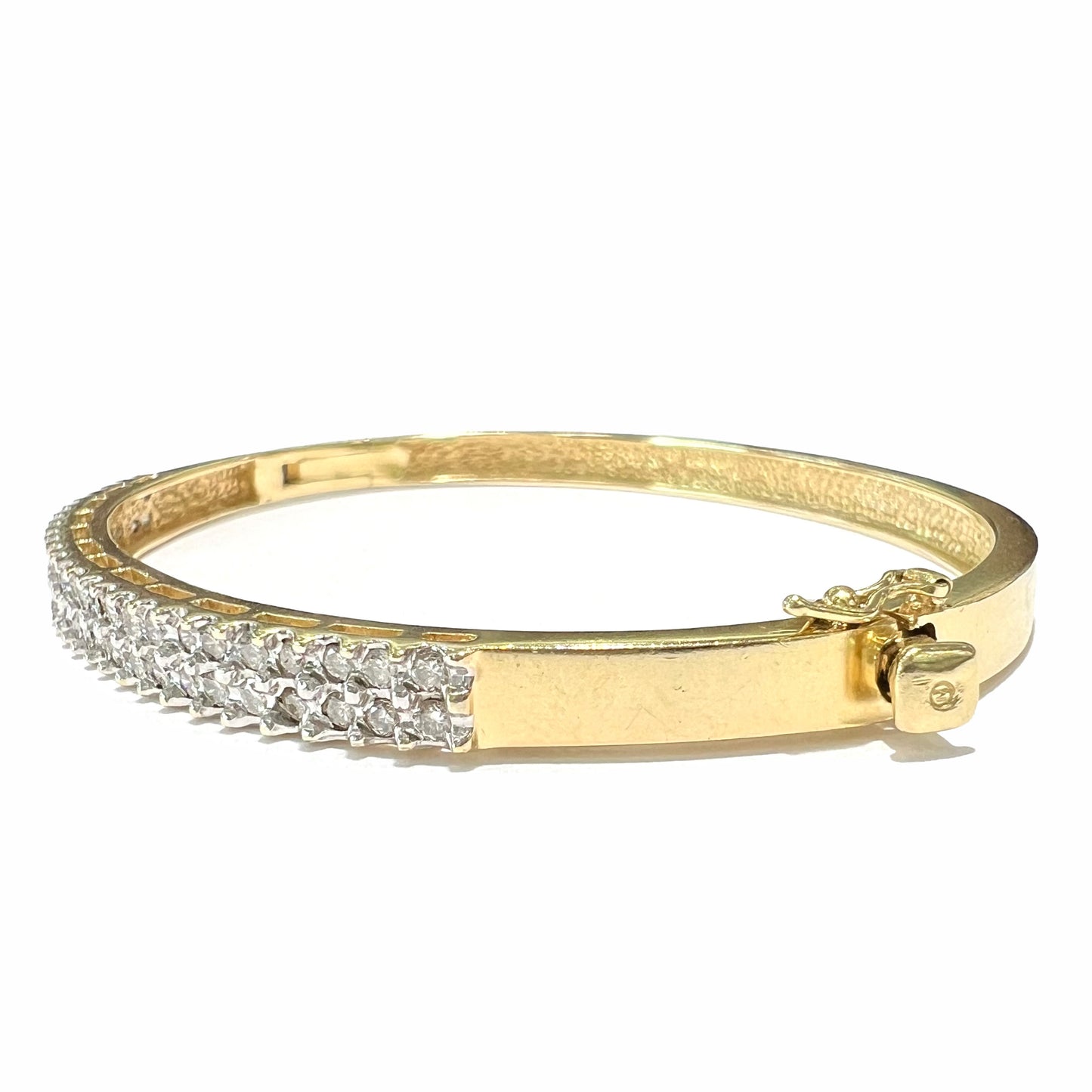 A ladies' hinged yellow gold bangle bracelet set with 50 Standard Round Brilliant Cut diamonds.