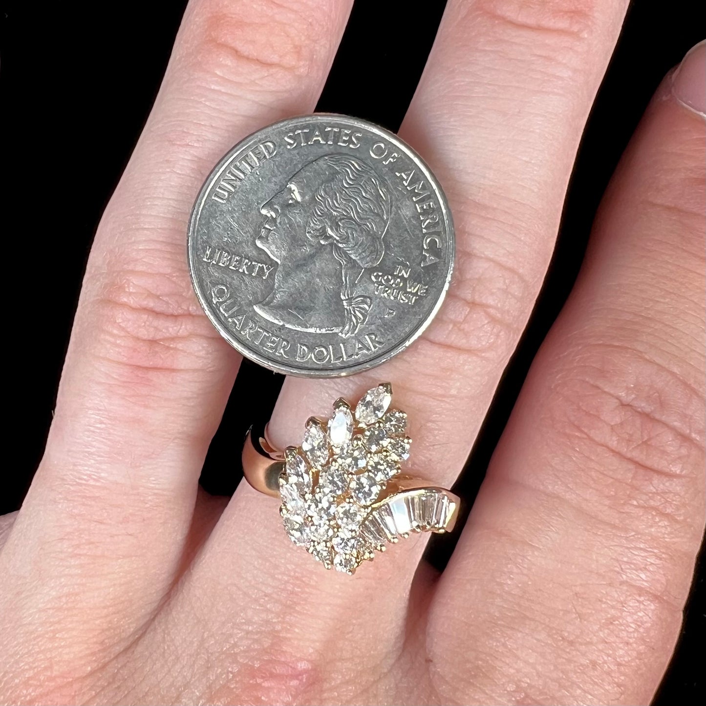 A yellow gold diamond cluster ring set with round, marquise, and baguette cut diamonds.