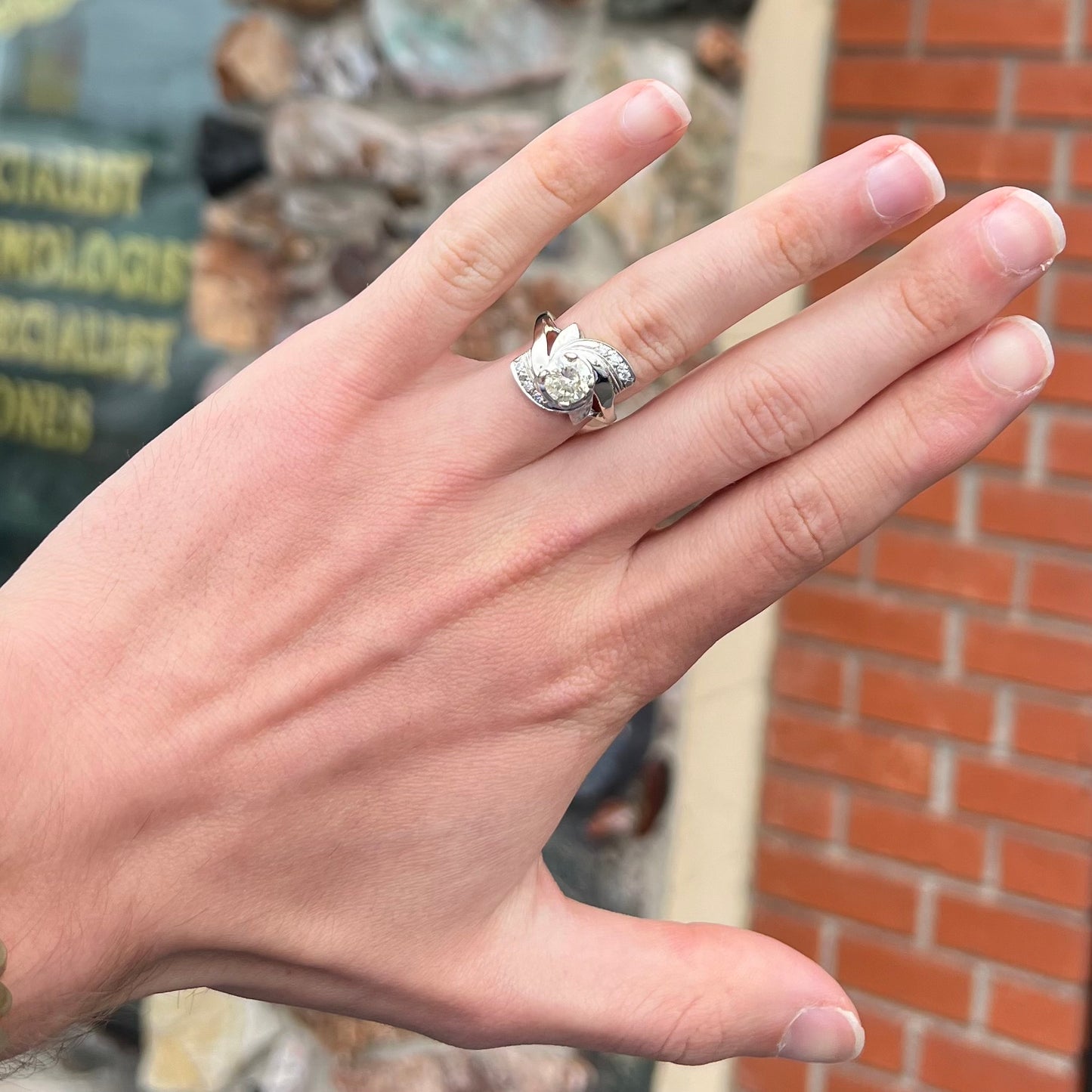 A vintage, Art Nouveau style diamond engagment ring. The ring is white gold with a yellowish, M colored, 1.24 carat diamond.