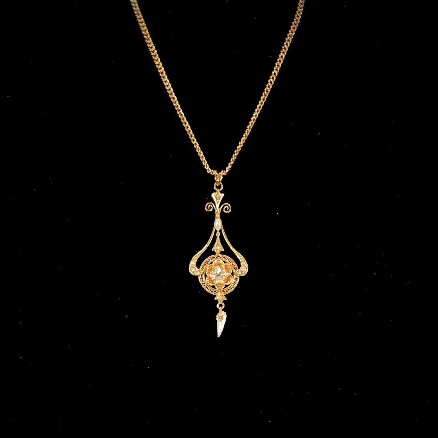 A ladies' Edwardian style gold necklace set with pearls and an old mine cut diamond.  The chain is marked "1916".