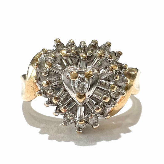 A ladies' heart shaped diamond cluster ring.  The ring is set with pear shaped, baguette cut, and round diamonds.
