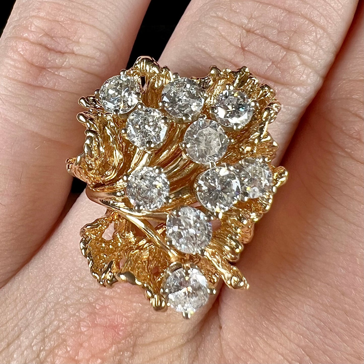 A ladies' 1950's style yellow gold and diamond cluster ring. The ring is shaped like a leaf with 10 round diamonds set in it.