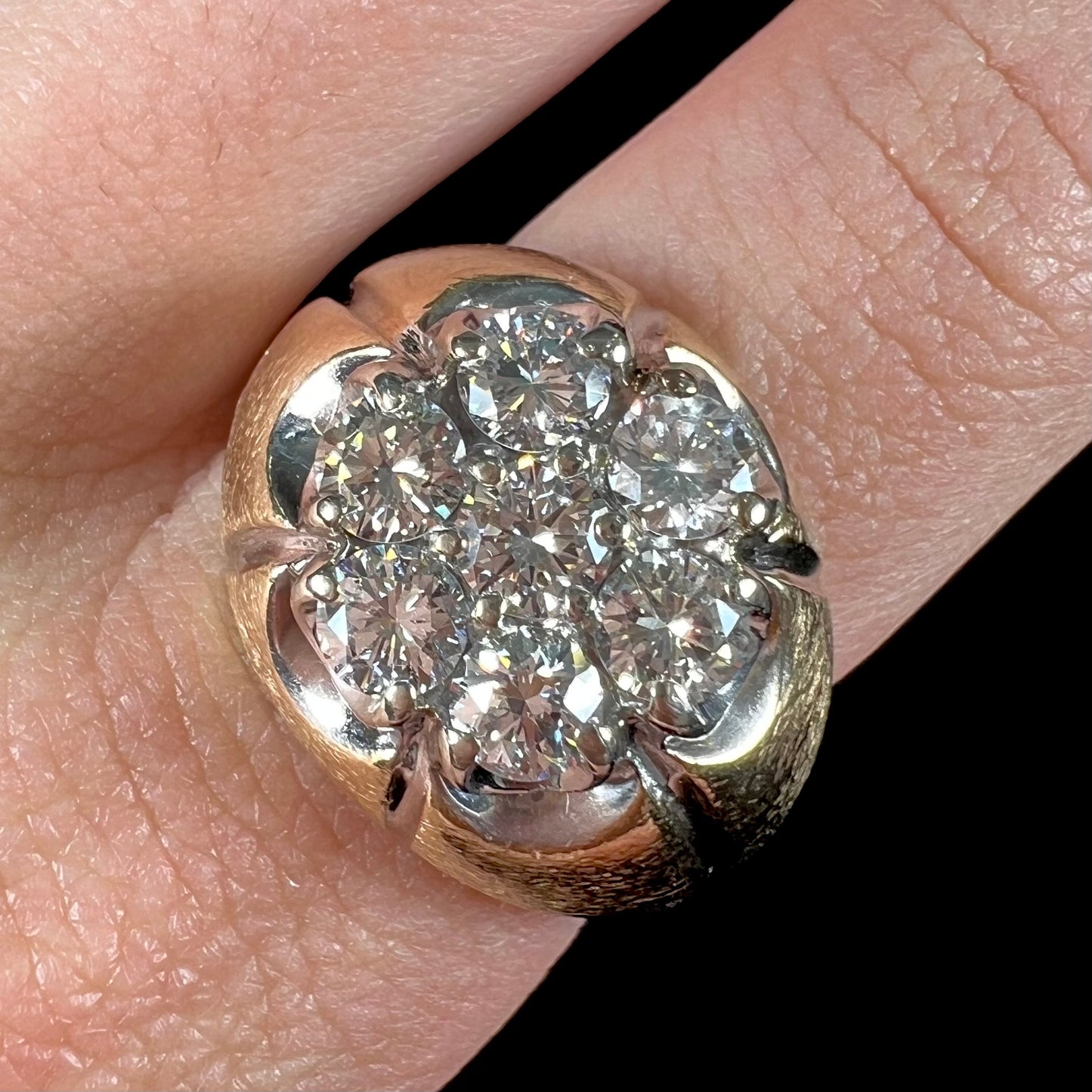 A men's textured yellow gold ring set with a cluster of seven round brilliant cut natural diamonds.