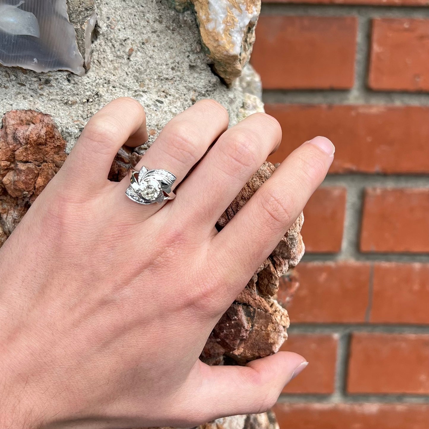 A vintage, Art Nouveau style diamond engagment ring.  The ring is white gold with a yellowish, M colored, 1.24 carat diamond.