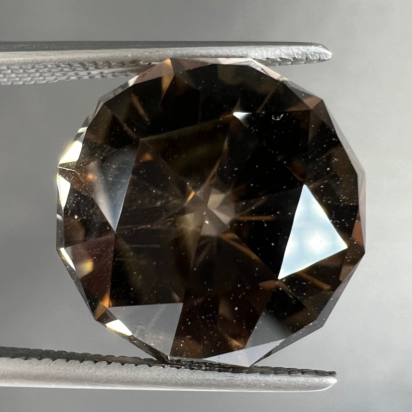 A loose, modified brilliant Portuguese cut smoky quartz gemstone.