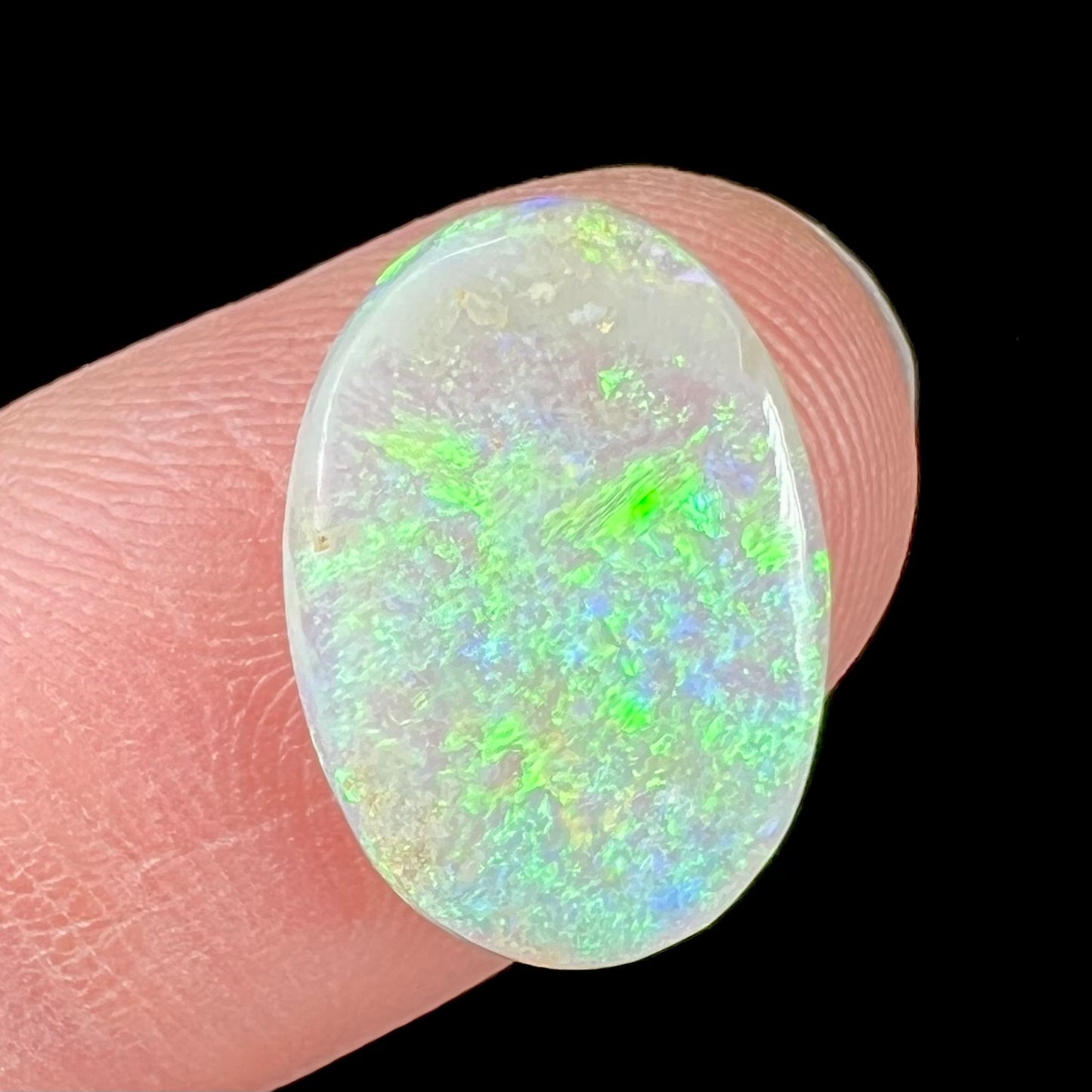 A double-sided opal stone from Coober Pedy, Australia. The opal plays green, blue, and orange colors from the front and the back.