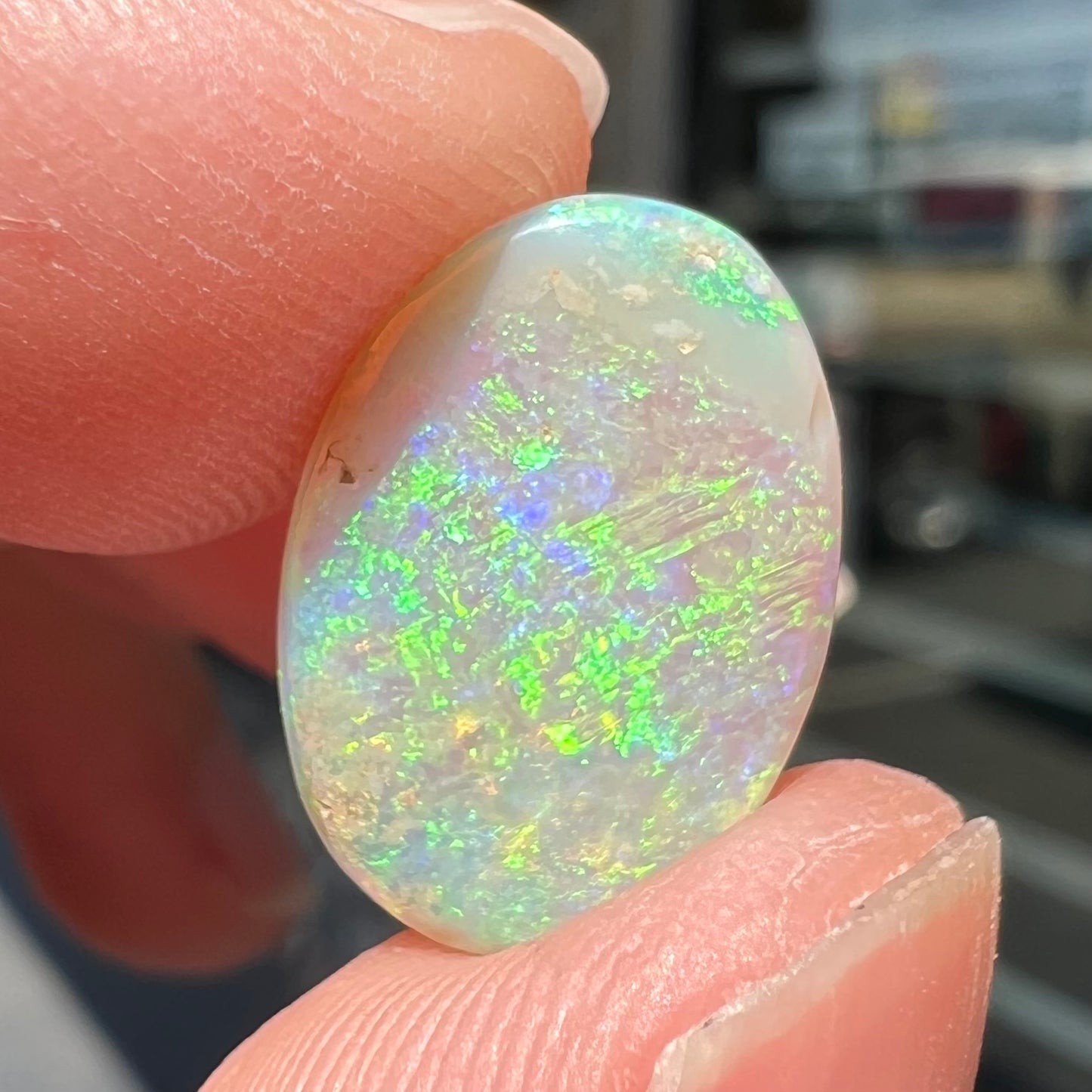 A double-sided opal stone from Coober Pedy, Australia. The opal plays green, blue, and orange colors from the front and the back.