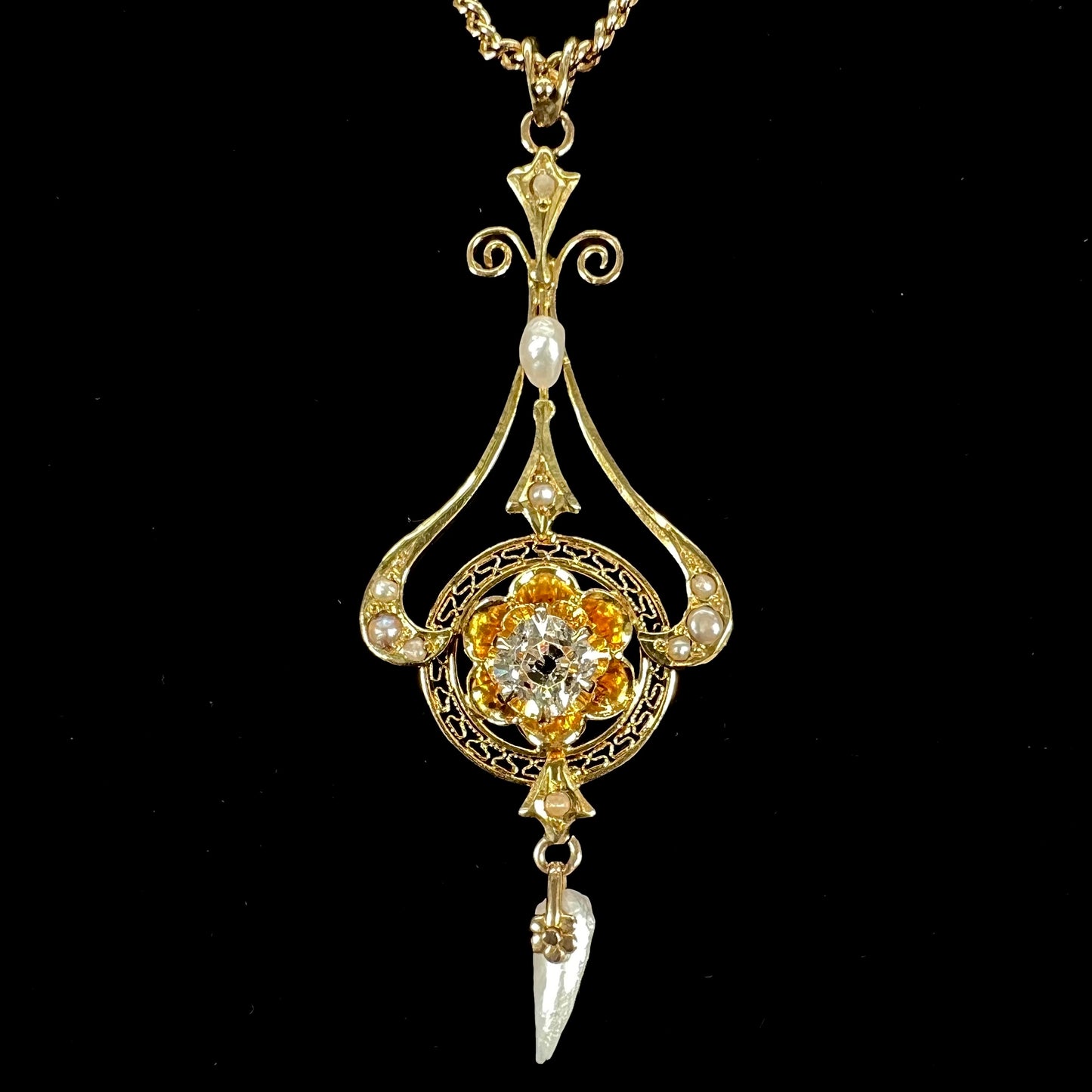 A ladies' Edwardian style gold necklace set with pearls and an old mine cut diamond.  The chain is marked "1916".