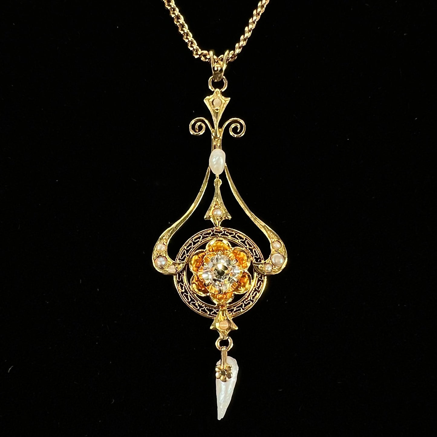 A ladies' Edwardian style gold necklace set with pearls and an old mine cut diamond.  The chain is marked "1916".