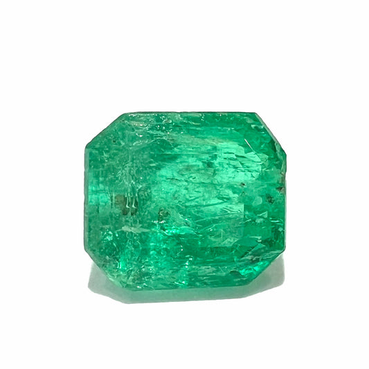 A loose, emerald cut natural emerald gemstone.