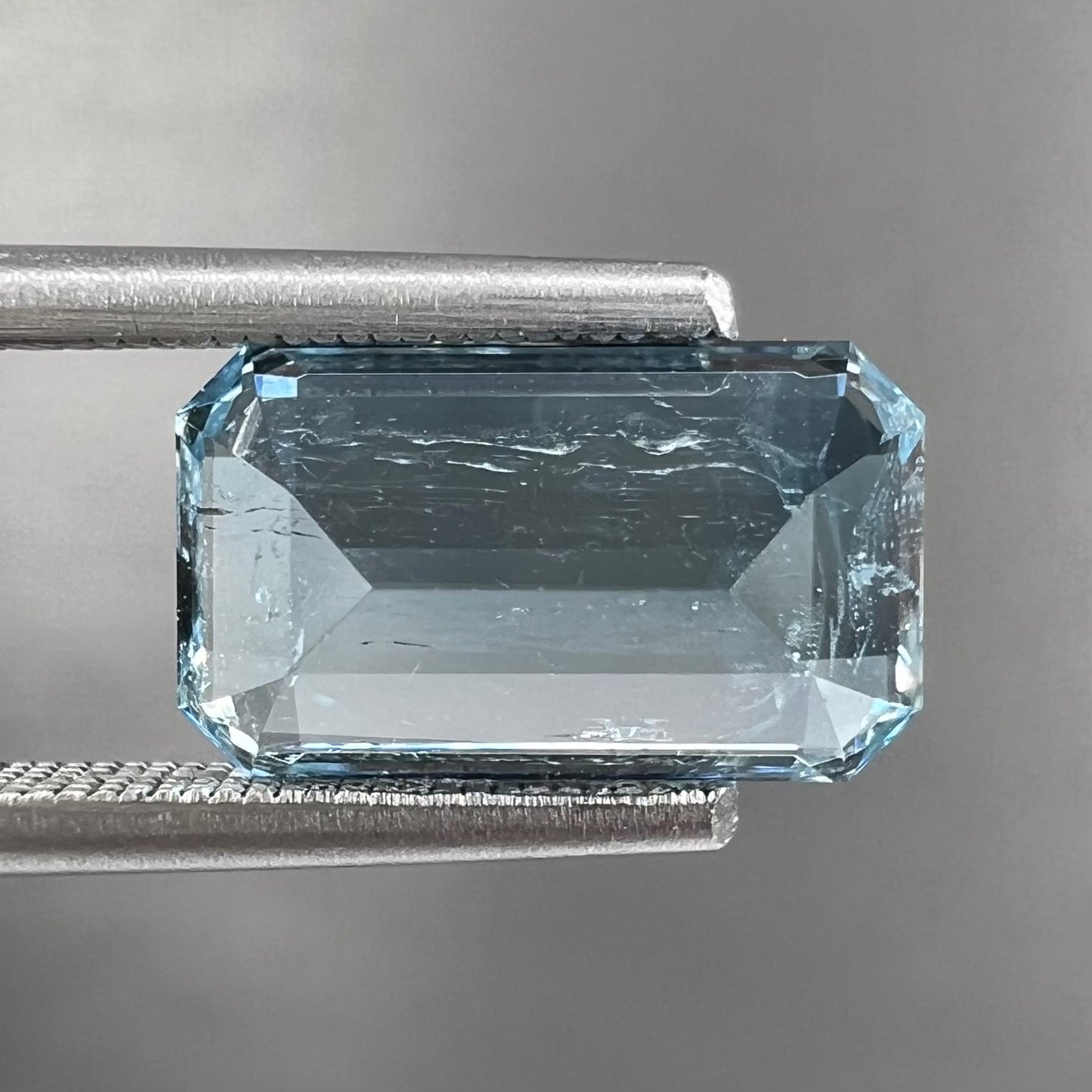 A loose, faceted emerald cut aquamarine stone. The stone is icy blue in color, indicative of Vietnamese origin.