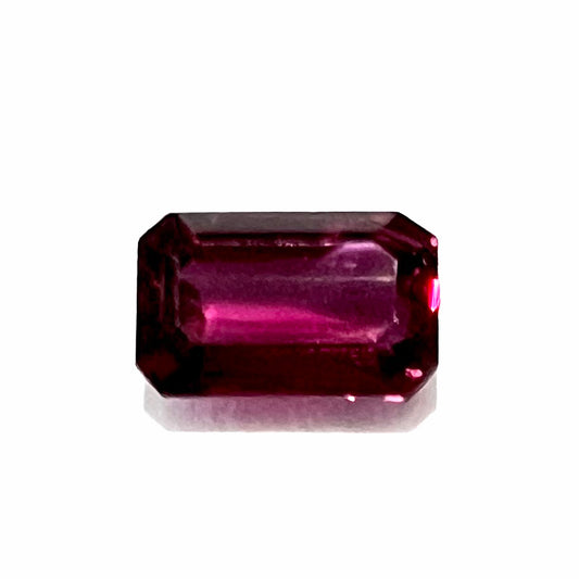 An emerald cut purplish red natural ruby stone.