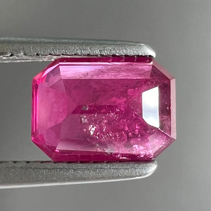 A natural, emerald cut Burma ruby with a purplish pinkish red color.