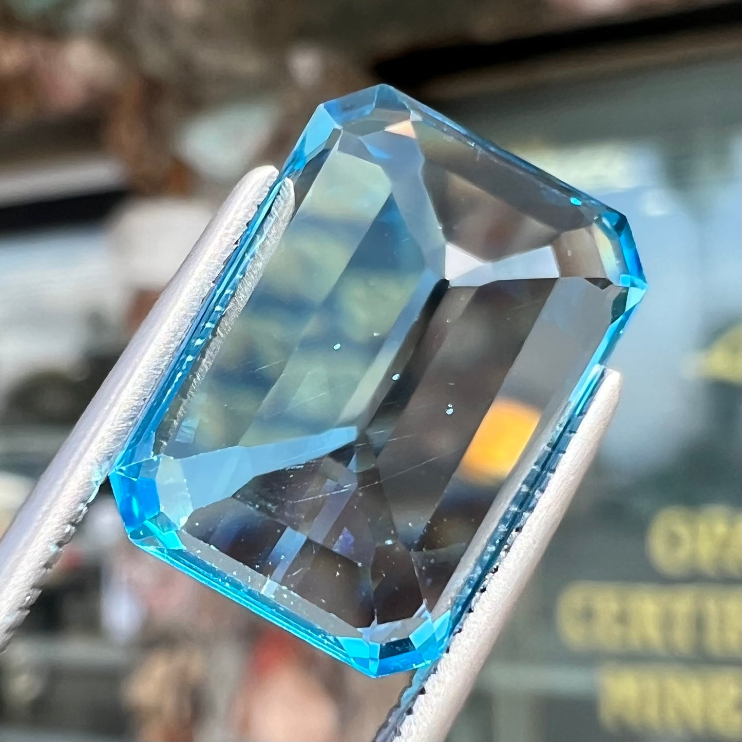 An emerald cut Swiss blue topaz gemstone. The stone is an electric blue color.