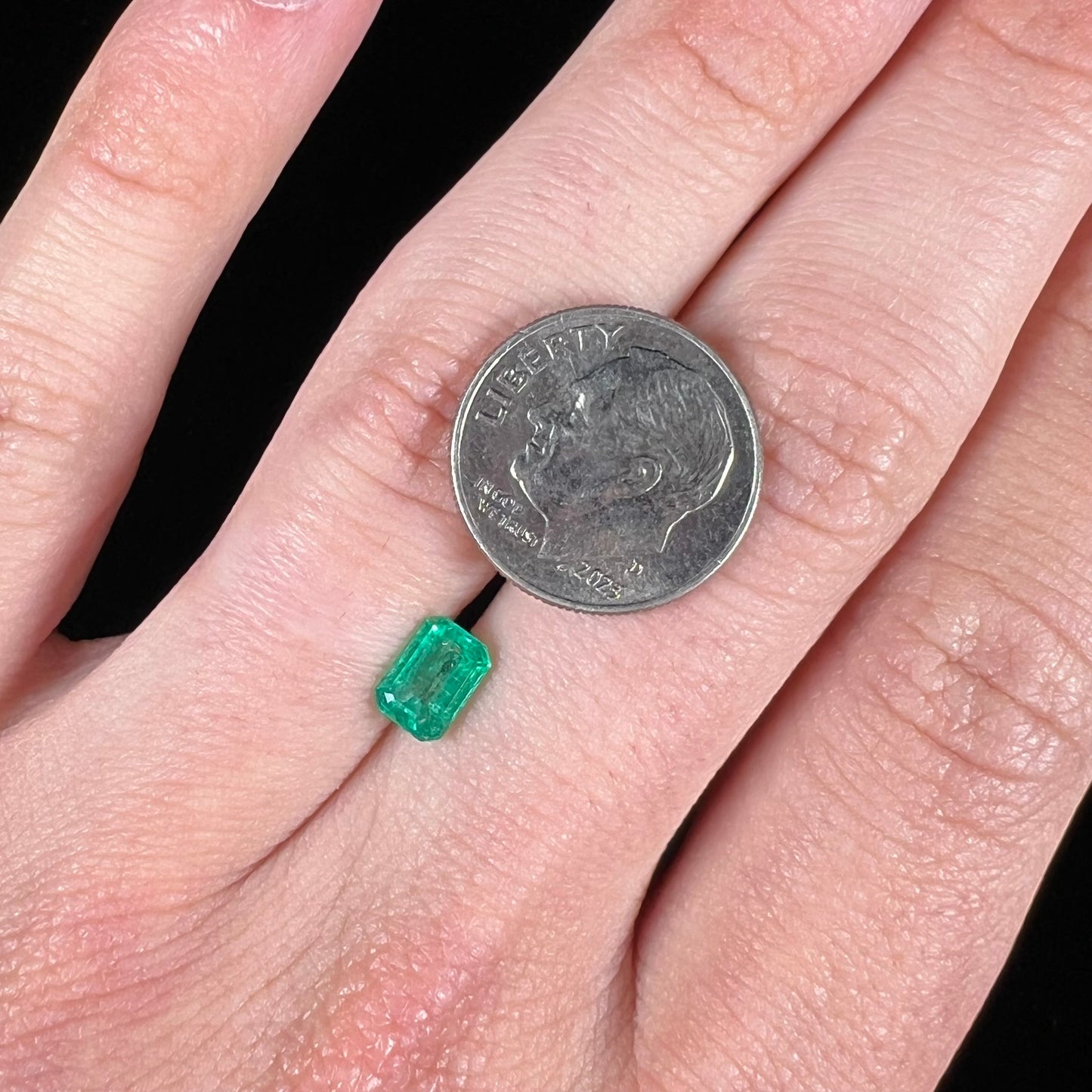 A loose, natural emerald gemstone. The stone is emerald cut.