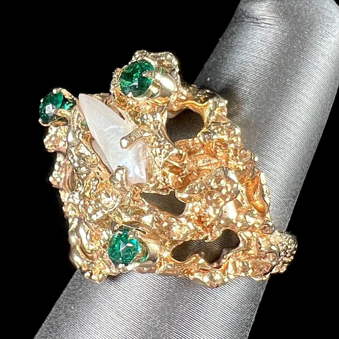 A vintage 1950's gold cluster ring set with freshwater pearls and green imitation emeralds.