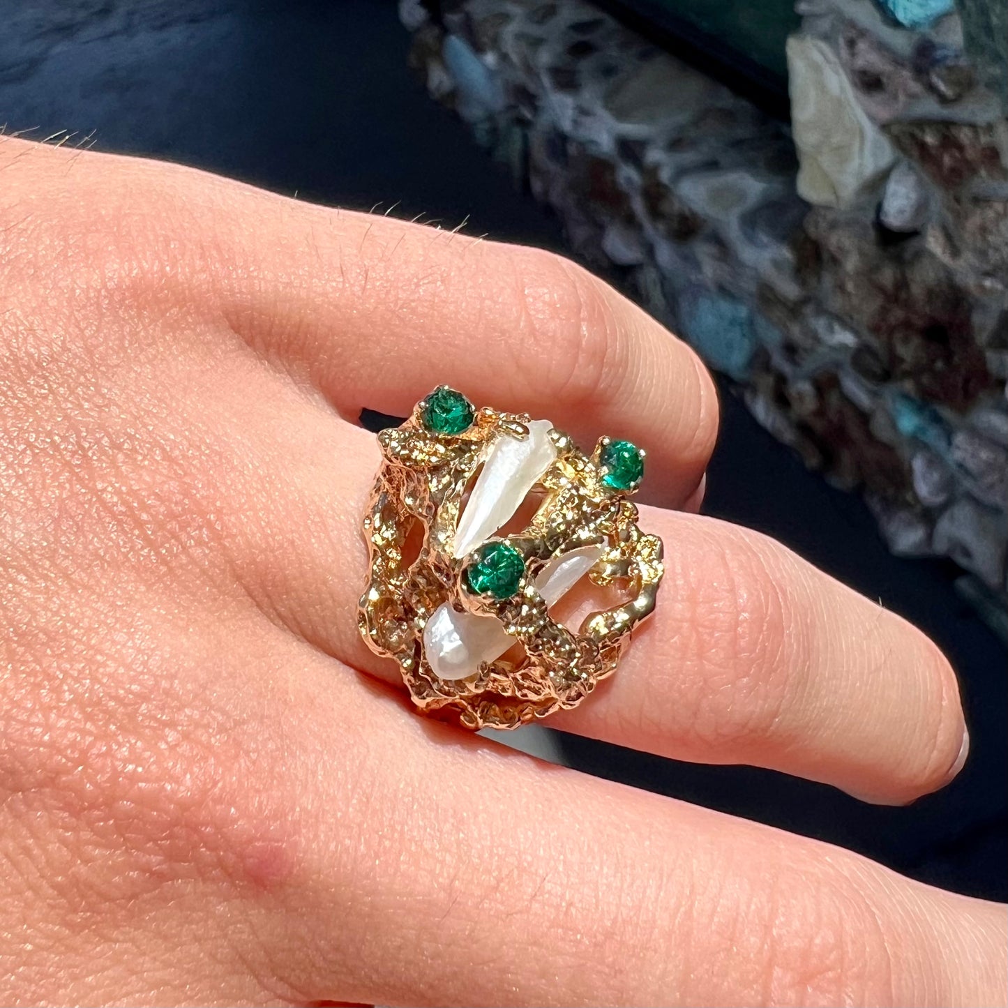 A vintage 1950's gold cluster ring set with freshwater pearls and green imitation emeralds.