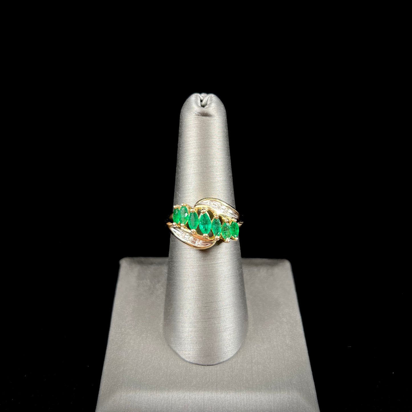 A vintage, 1970's style yellow gold ring set with marquise cut emeralds and round brilliant cut diamonds.