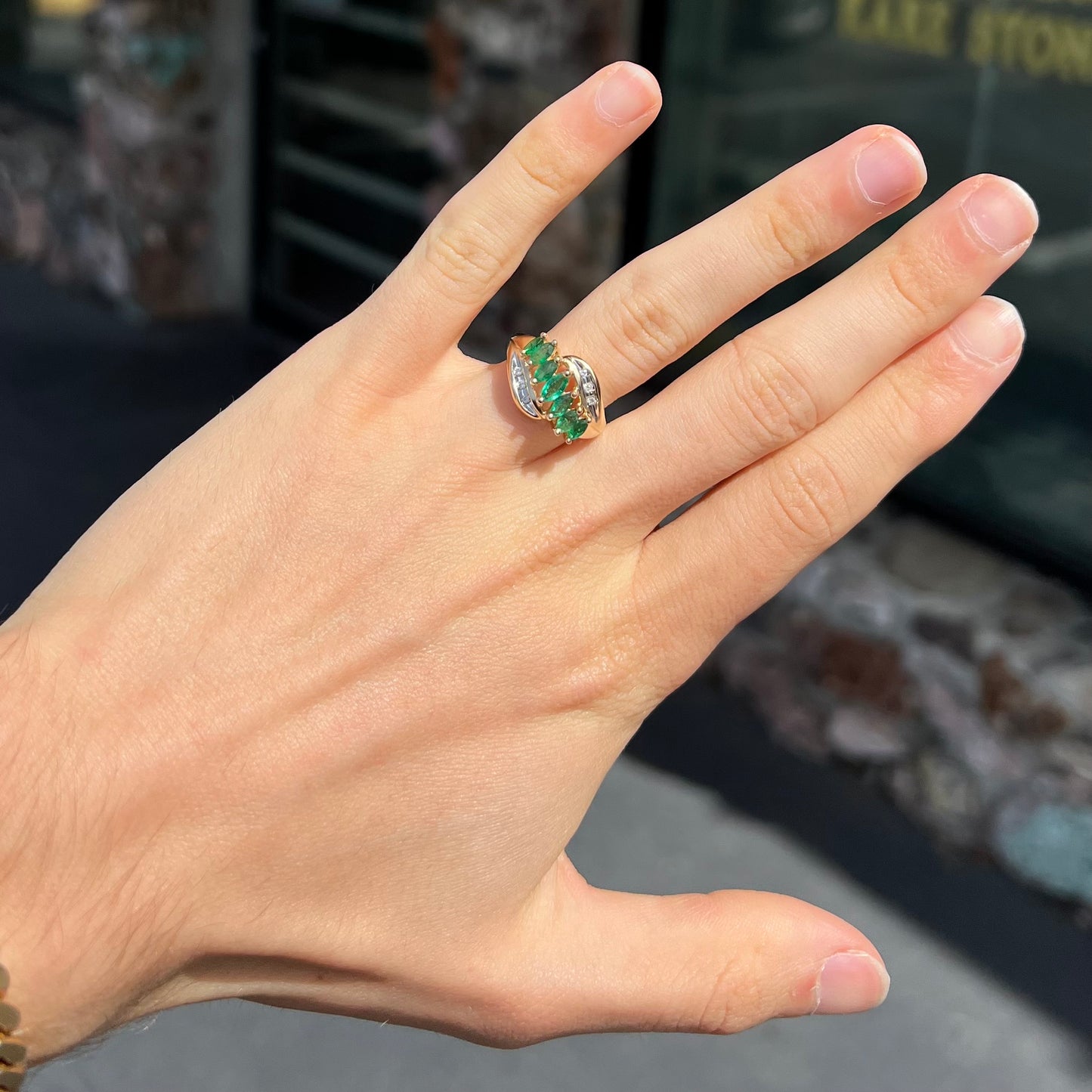 A vintage, 1970's style yellow gold ring set with marquise cut emeralds and round brilliant cut diamonds.