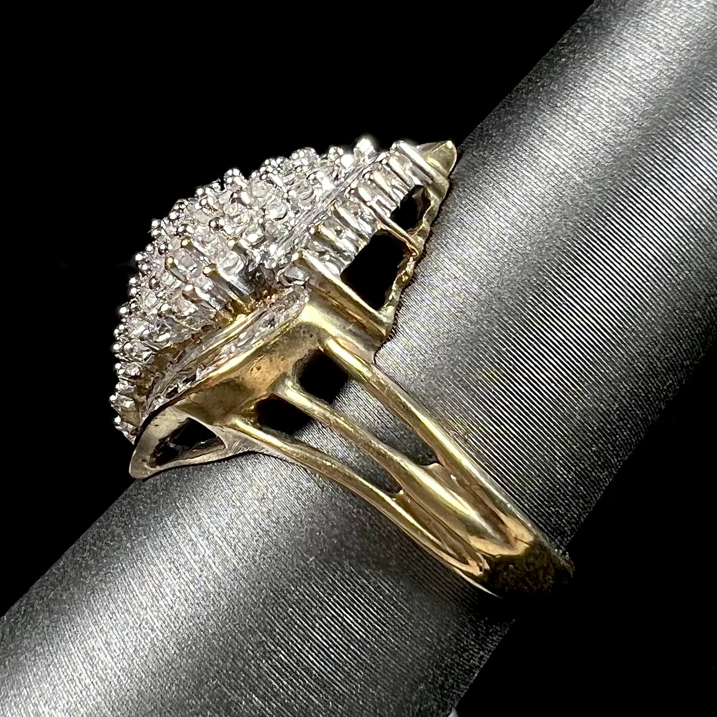 A ladies' yellow gold and diamond cluster ring. The diamonds are round and baguette shaped, and the ring is navette shaped.