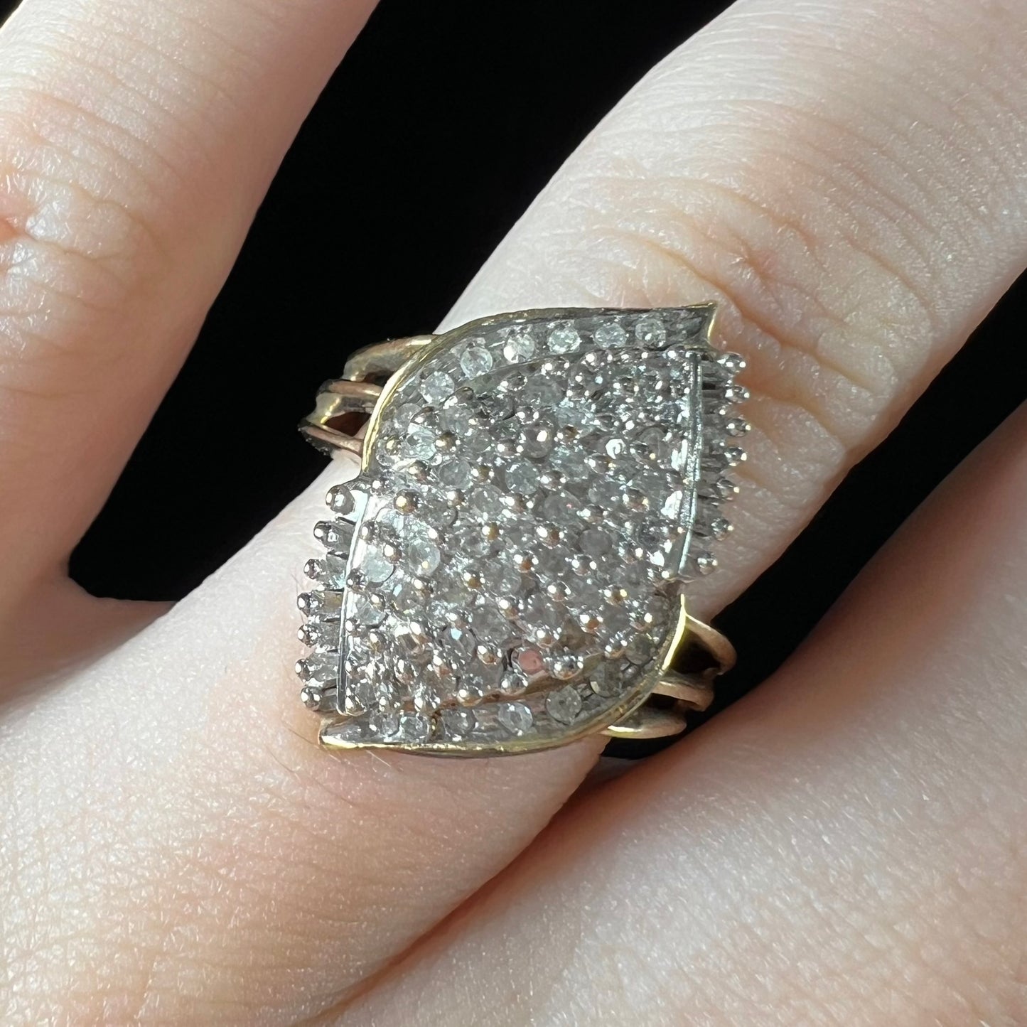 A ladies' yellow gold and diamond cluster ring. The diamonds are round and baguette shaped, and the ring is navette shaped.