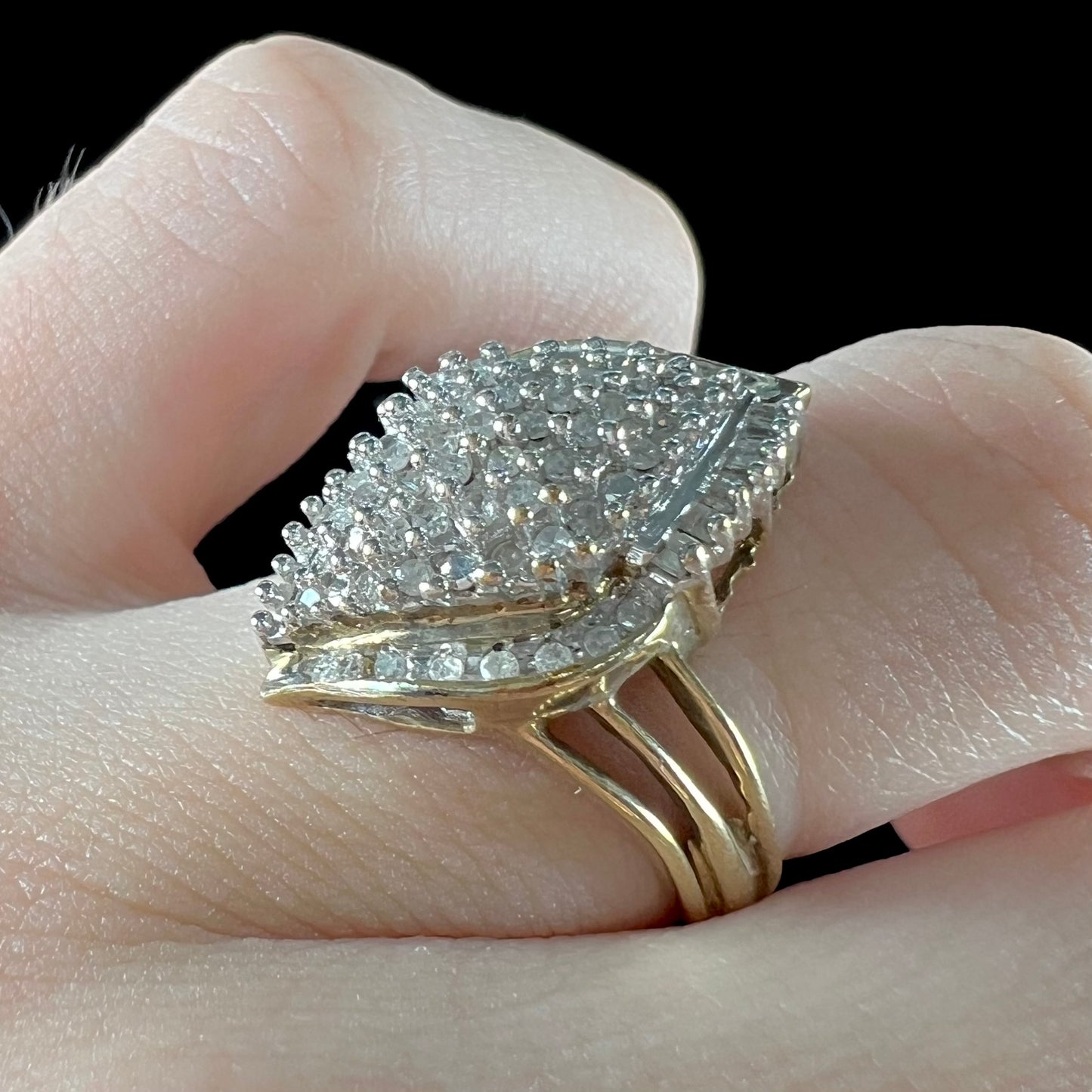 A ladies' yellow gold and diamond cluster ring. The diamonds are round and baguette shaped, and the ring is navette shaped.