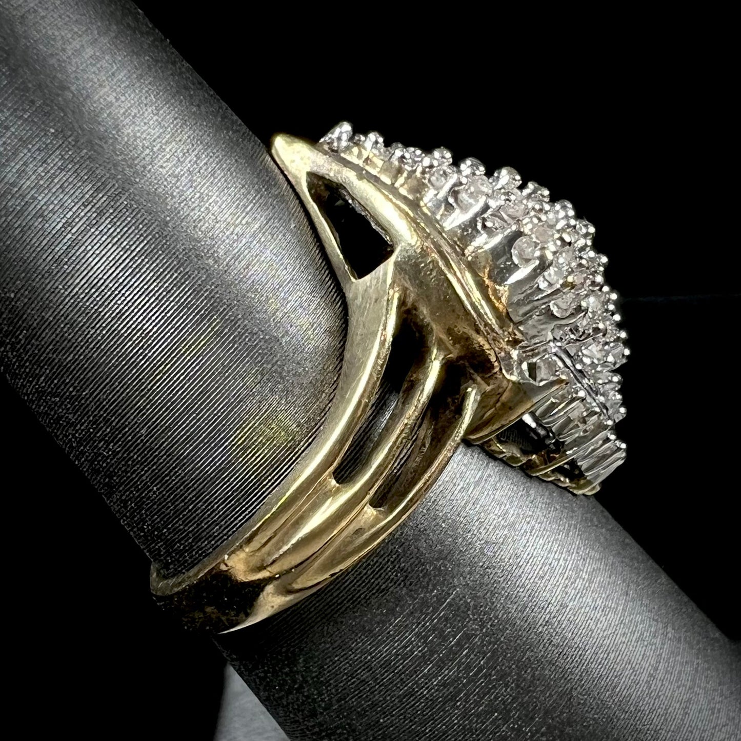 A ladies' yellow gold and diamond cluster ring. The diamonds are round and baguette shaped, and the ring is navette shaped.