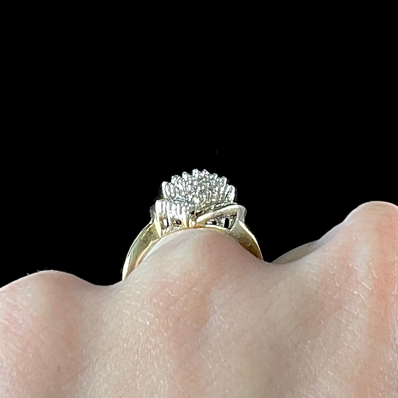 A ladies' yellow gold and diamond cluster ring. The diamonds are round and baguette shaped, and the ring is navette shaped.