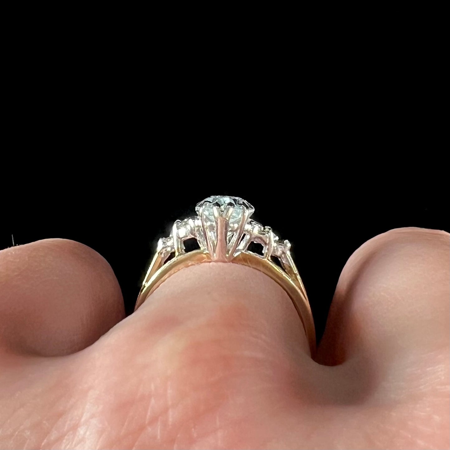 A ladies' ring set with a marquise cut aquamarine and round accent diamonds.