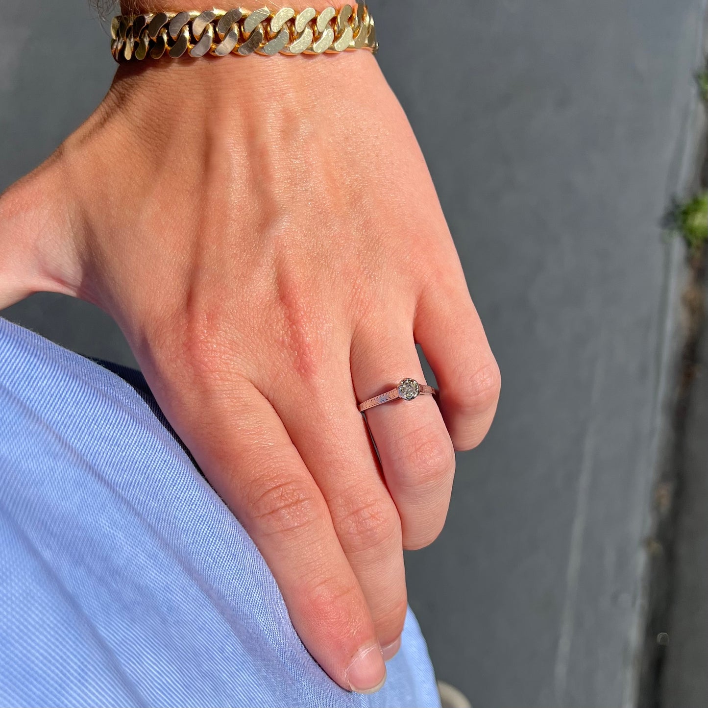 An Art Deco style 18 karat white gold diamond solitaire ring. The ring has scroll work on the side of the shank.