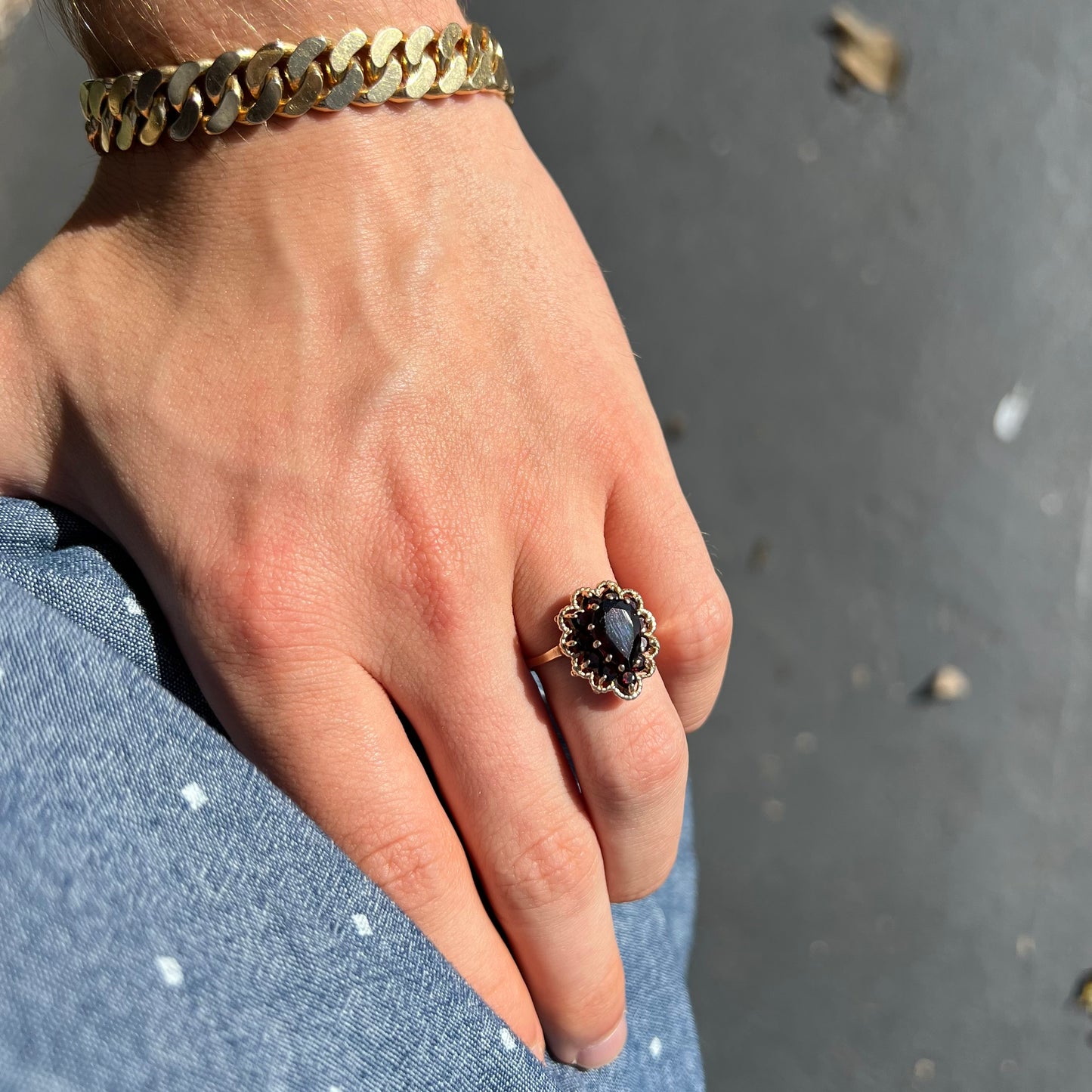 A vintage, 1940's style yellow gold ring set with a pear shaped almandine garnet. A halo of round garnets surround the center stone.