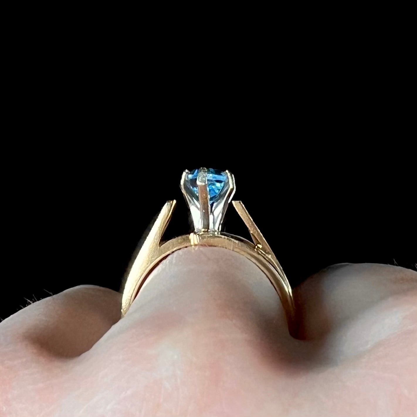 A ladies' estate yellow gold ring, prong set with a marquise cut blue topaz stone. There are scratches on the shank.