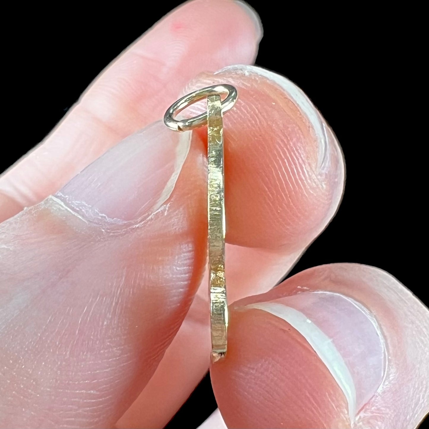 A 14 karat yellow gold stylized script letter "B" pendant, resembling the Barbie logo.