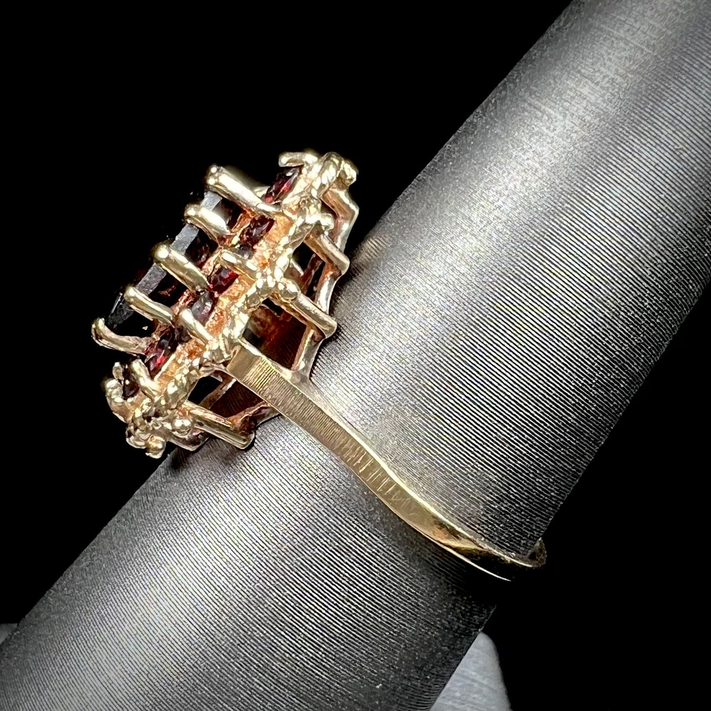 A vintage, 1940's style yellow gold ring set with a pear shaped almandine garnet. A halo of round garnets surround the center stone.