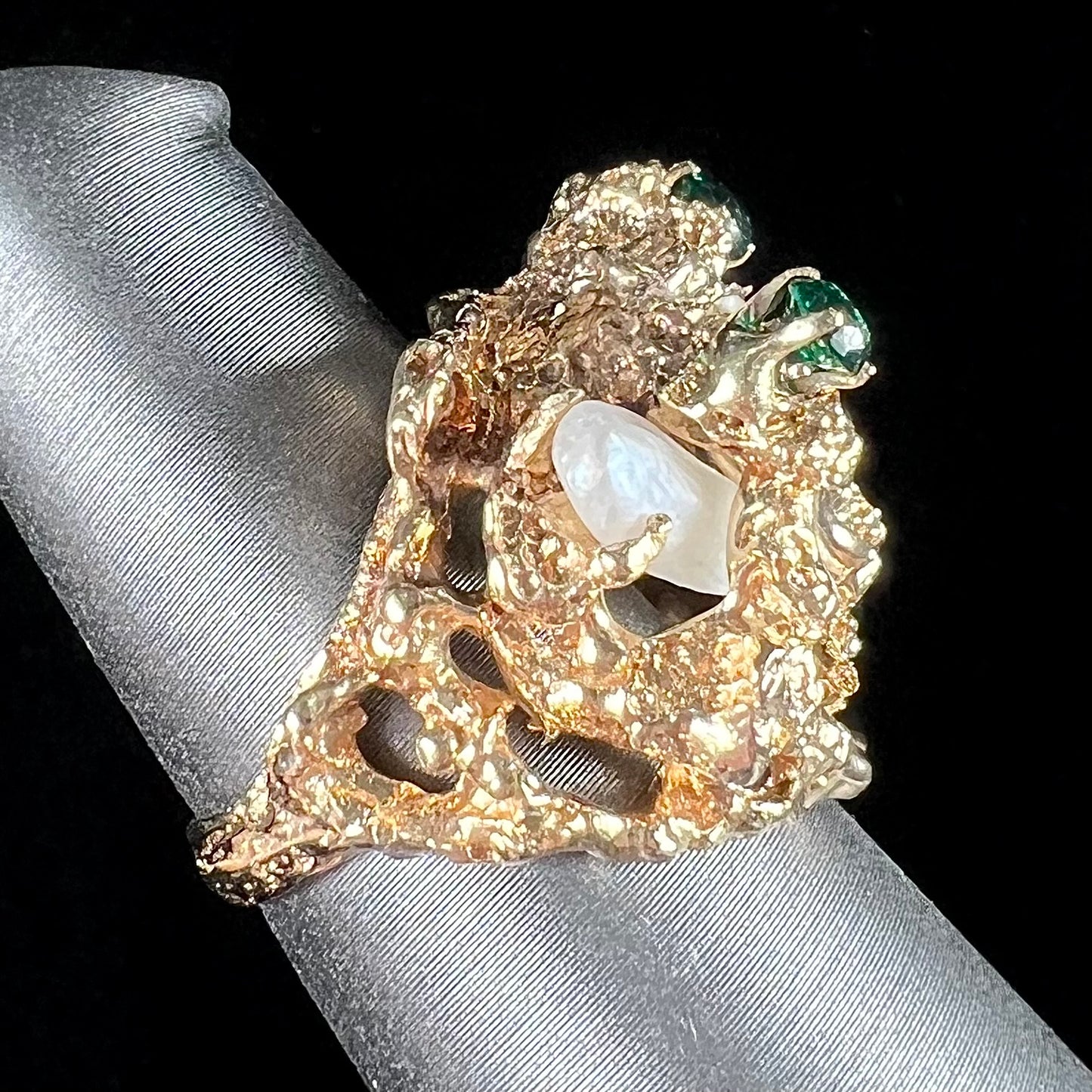 A vintage 1950's gold cluster ring set with freshwater pearls and green imitation emeralds.