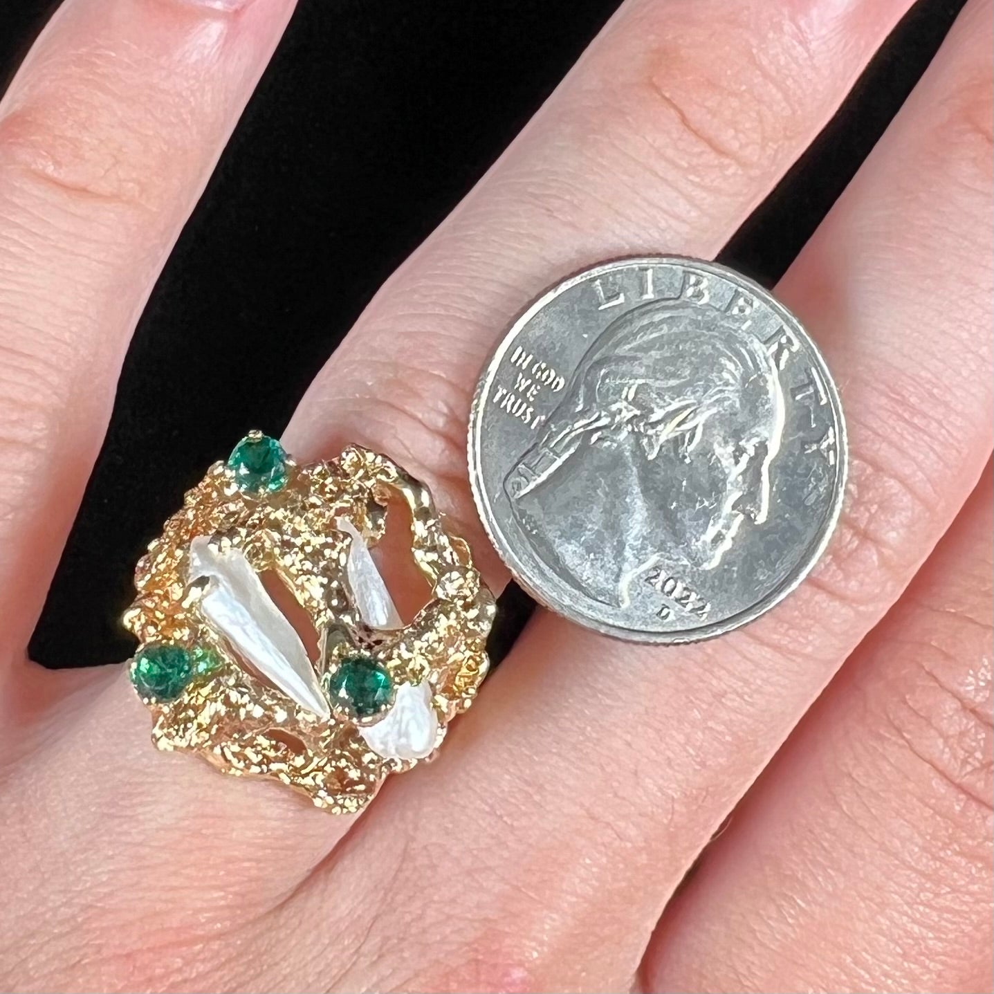 A vintage 1950's gold cluster ring set with freshwater pearls and green imitation emeralds.