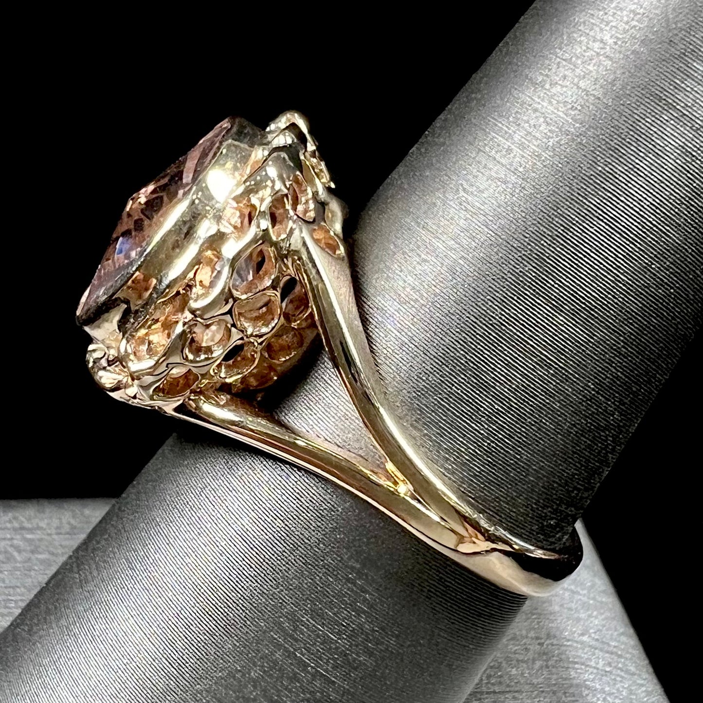 A ladies' yellow gold solitaire ring bezel set with a modified bud cut morganite gemstone.