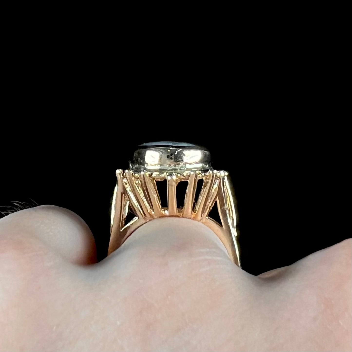 A ladies' yellow gold solitaire ring mounted with a gray trapiche star sapphire.