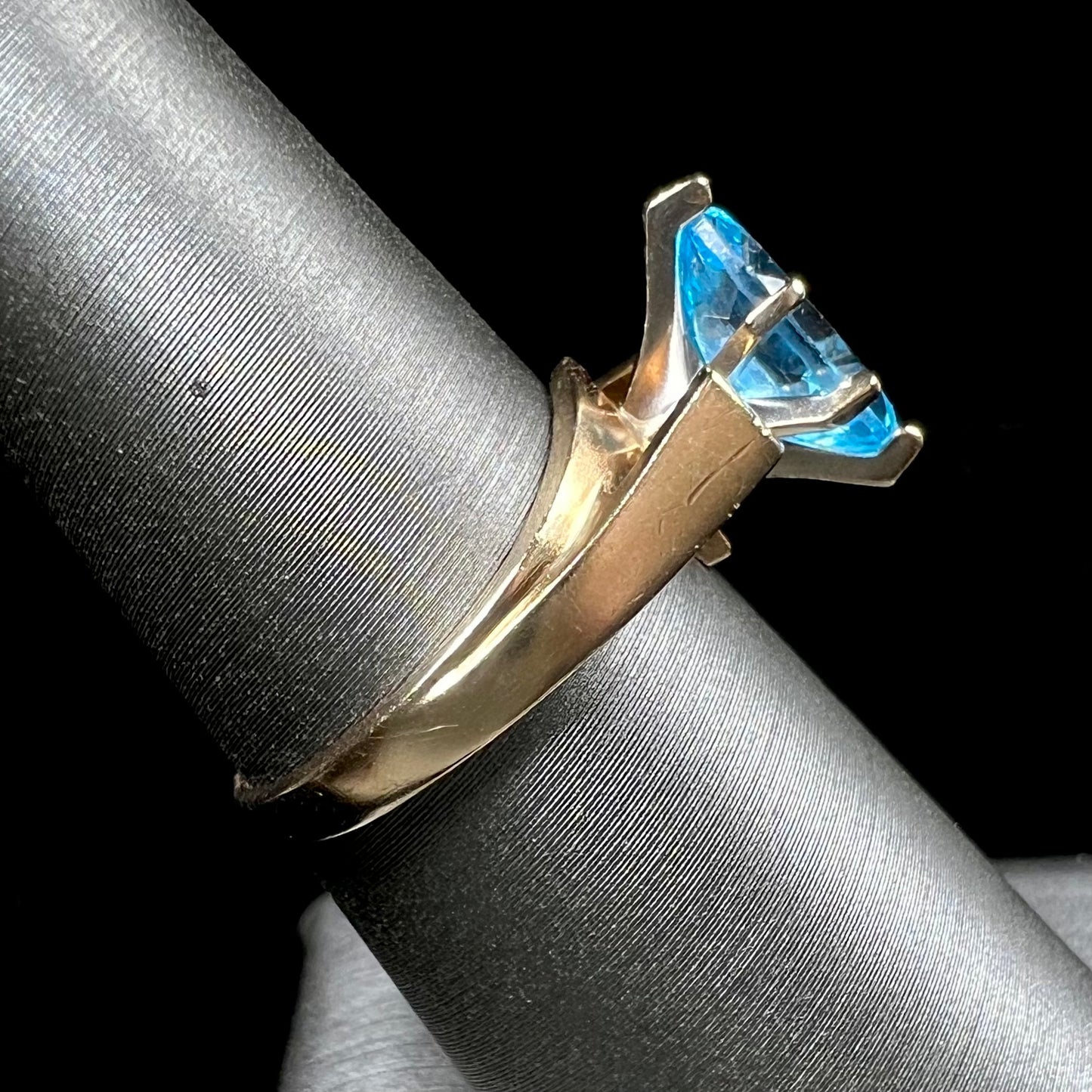 A ladies' estate yellow gold ring, prong set with a marquise cut blue topaz stone. There are scratches on the shank.