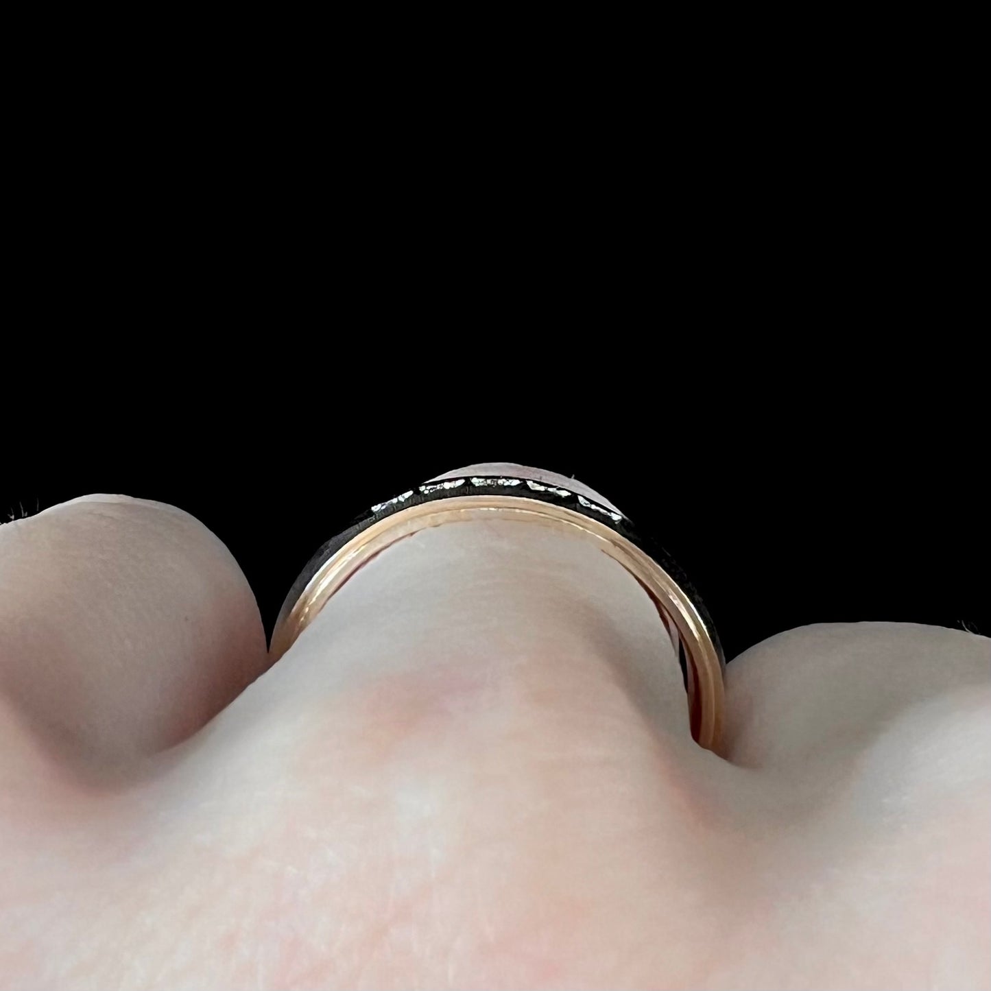 A unisex, two-tone white and yellow gold diamond wedding band. The white gold is textured.