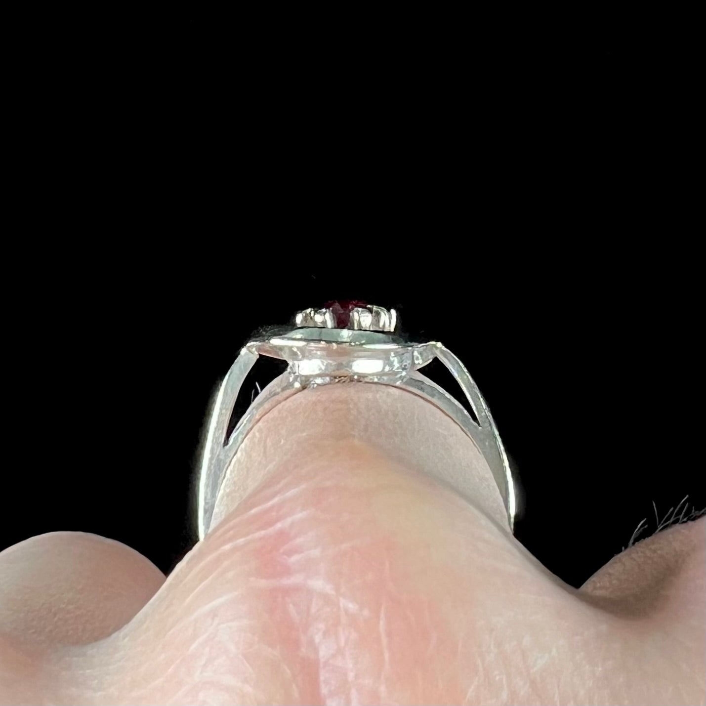 A ladies' estate white gold ruby ring set with a diamond accent stone.