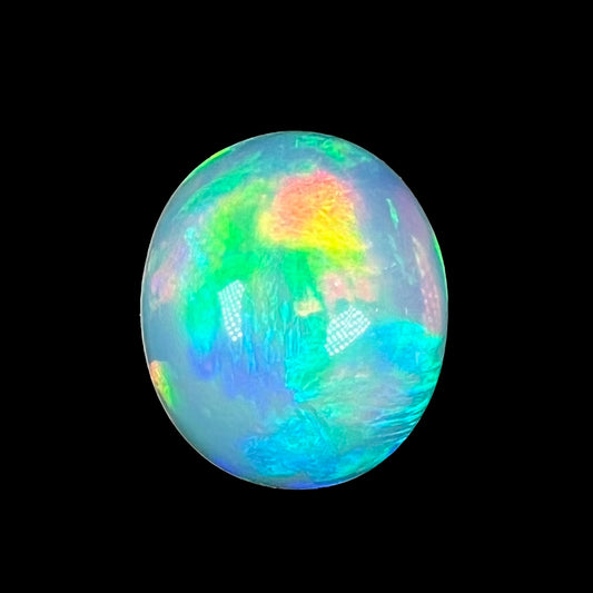 A loose, oval cabochon cut Ethiopian fire opal with a rainbow of colors.