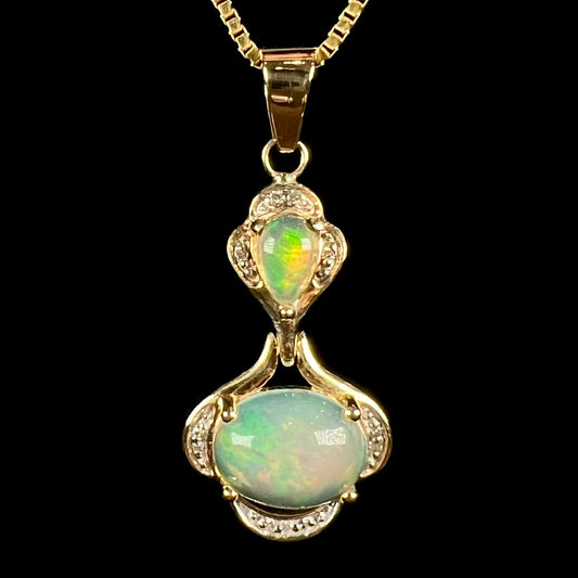 A ladies' yellow gold and diamond accented pendant set with two natural Ethiopian fire opals.